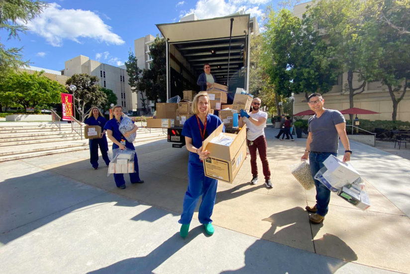 USC doctor Kenji Inaba, right, and other health care workers unpack protective medical supplies donated from the set of ABC’s Grey’s Anatomy.