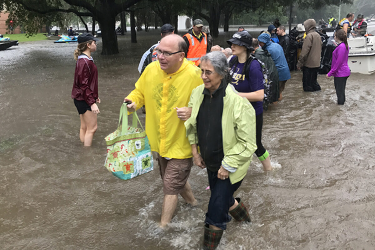 man woman walking through high water