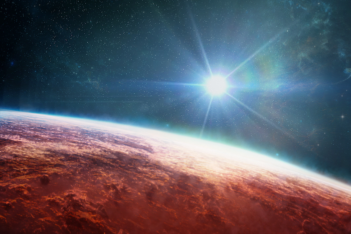 Picture from space showing the sun rising over a red planet