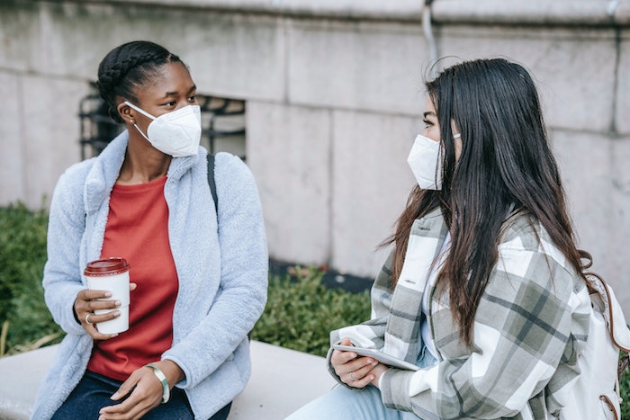 two masked individuals speaking
