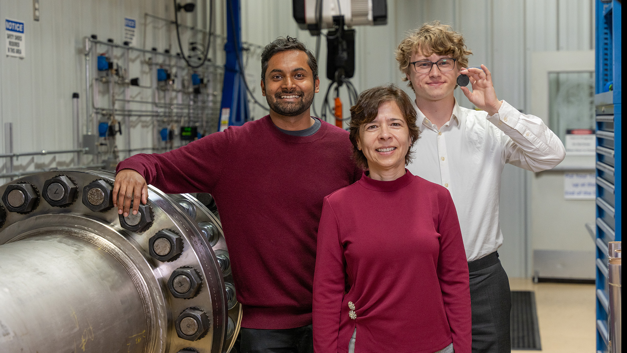 The research team stands in front of one of the hypersonics testing tunnels at the National Aerothermochemistry and Hypersonics Laboratory