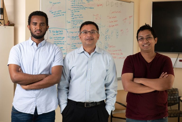 Yonatan Gizachew Achamyeleh, Mohammad Al Faruque, and Anomadarshi Barua standing in front of a whiteboard with writing on it