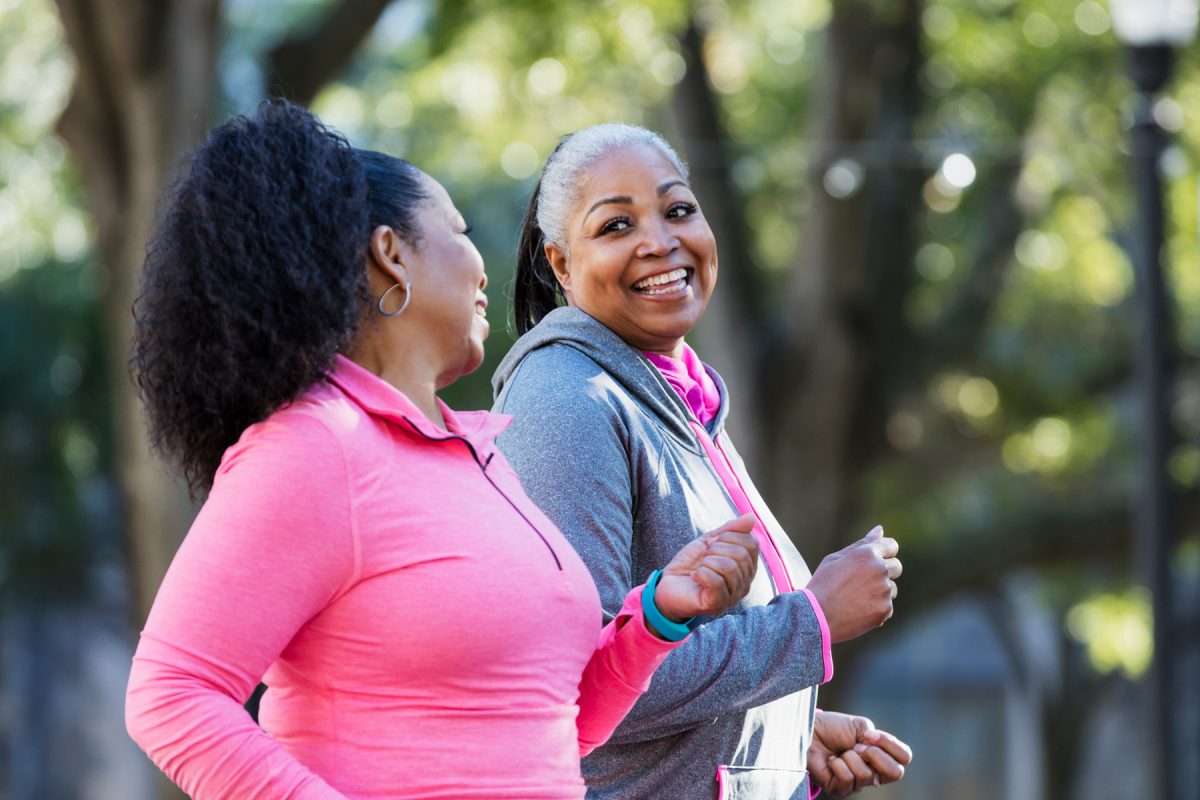 Two women jog together.