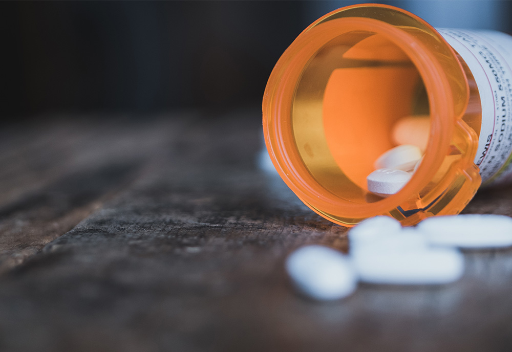 Bottle of opioid pills on a table with the cap open