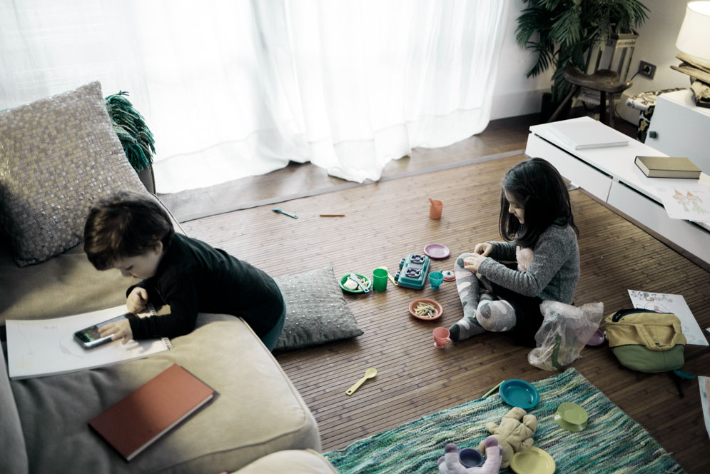 Children play near furniture.