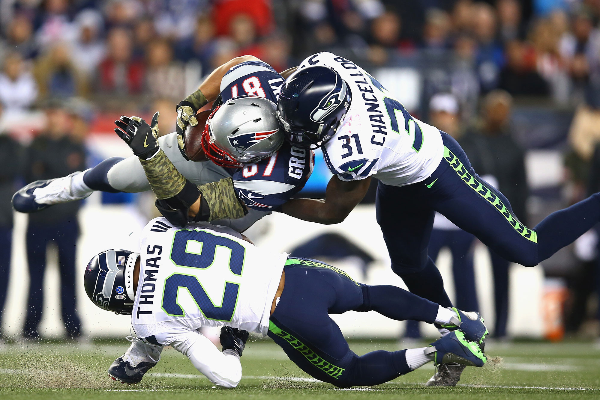 Patriot Rob Gronkowski is tackled by to Seahawks players.