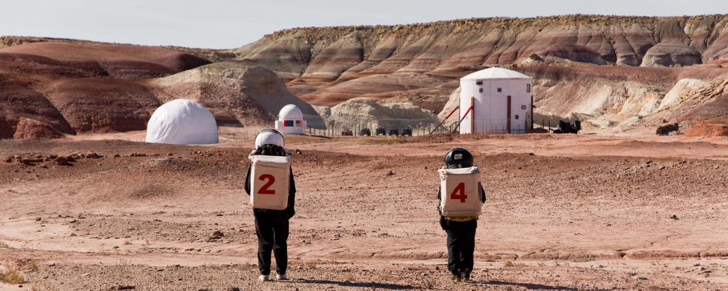 Astronauts walk through the Utah desert at the Mars Desert Research Station