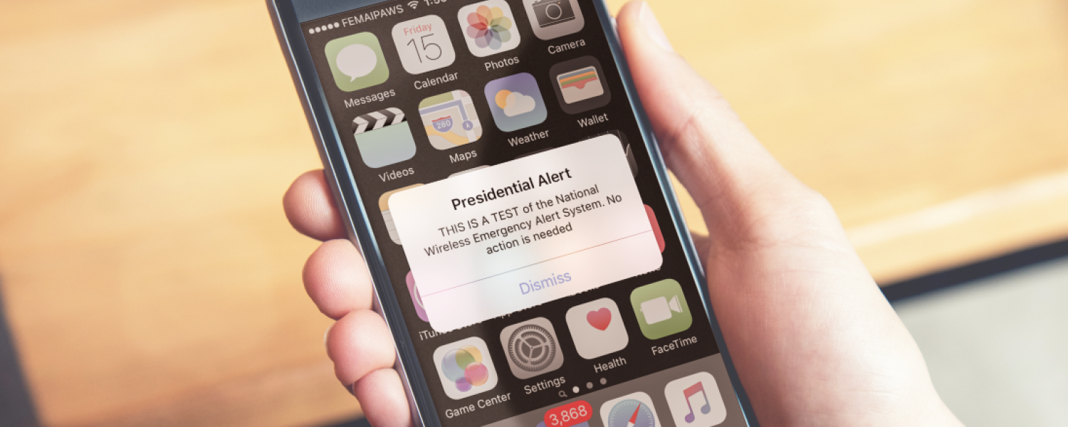 A cell phone shows a Presidential Alert.
