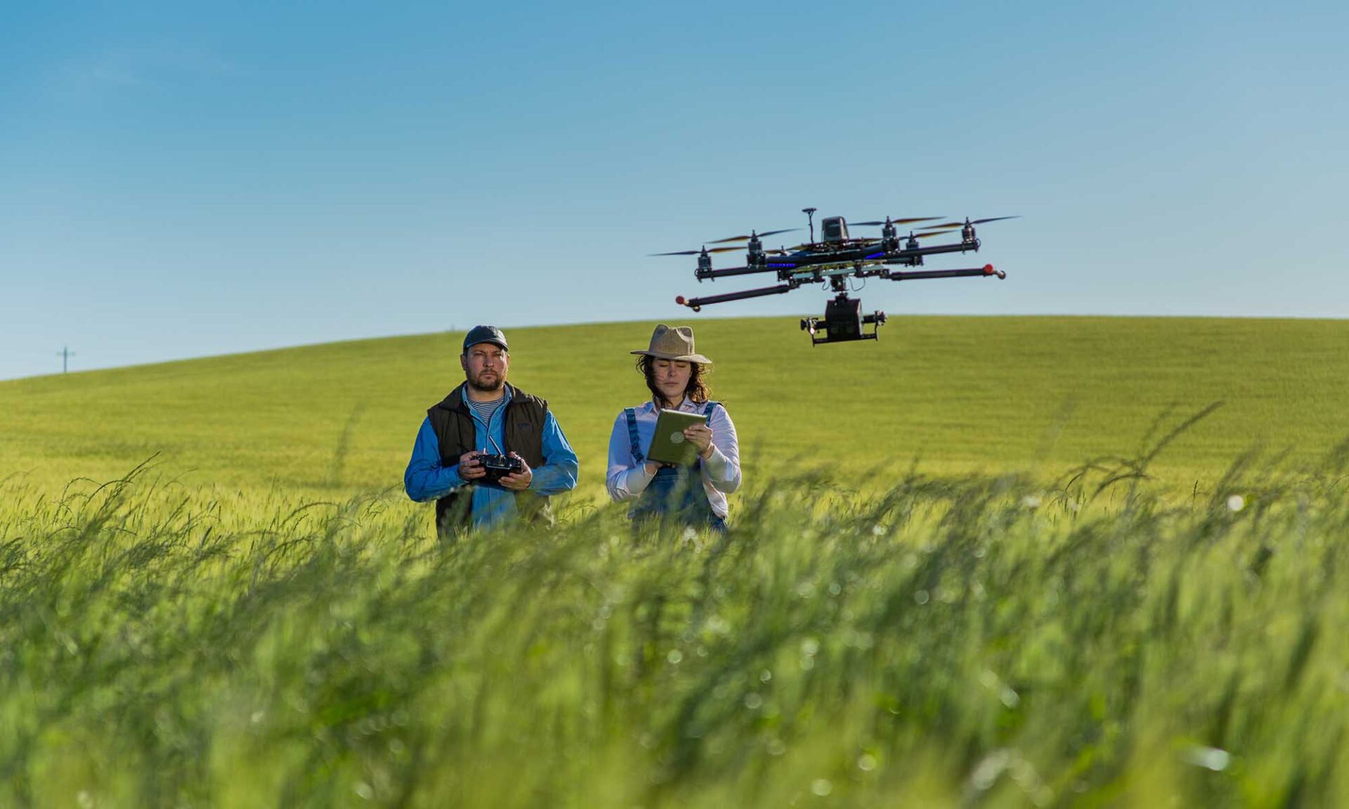 Engineers taking notes and flying a drone in a field