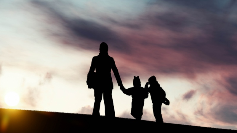 Silhouette of a person with two children.