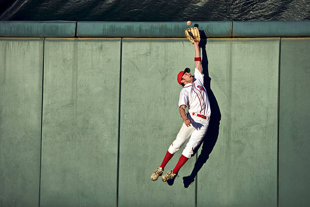 A baseball player reaching for a ball