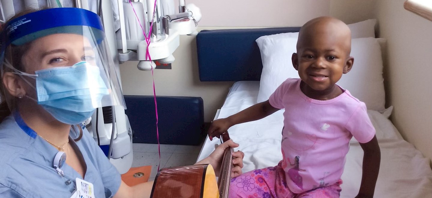 A music therapist with a child in a hospital