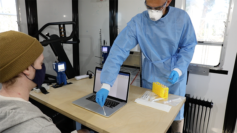 man swabbing laptop