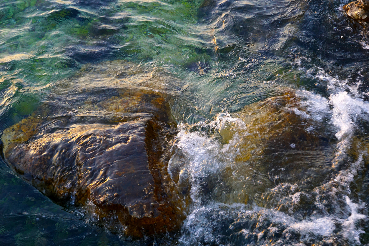 Rocks in the ocean with water flowing over them.