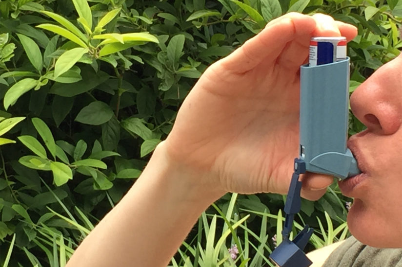 A person uses an inhaler.