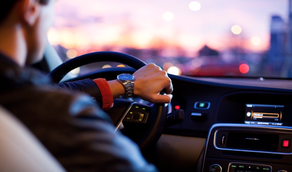 A person steers a car.