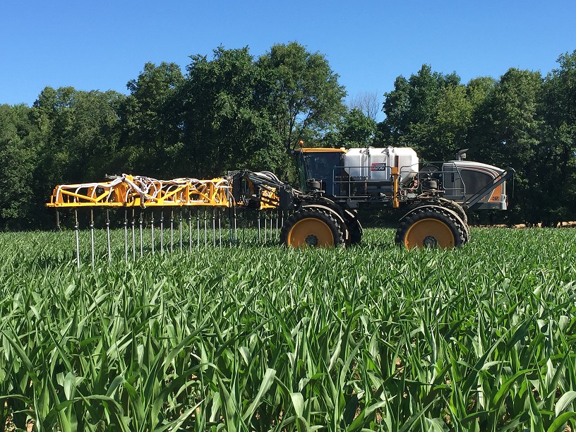 A tractor fertilizes a field.
