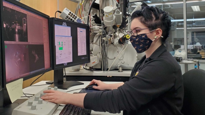 woman sitting at computer with mask modeling nanocrystals