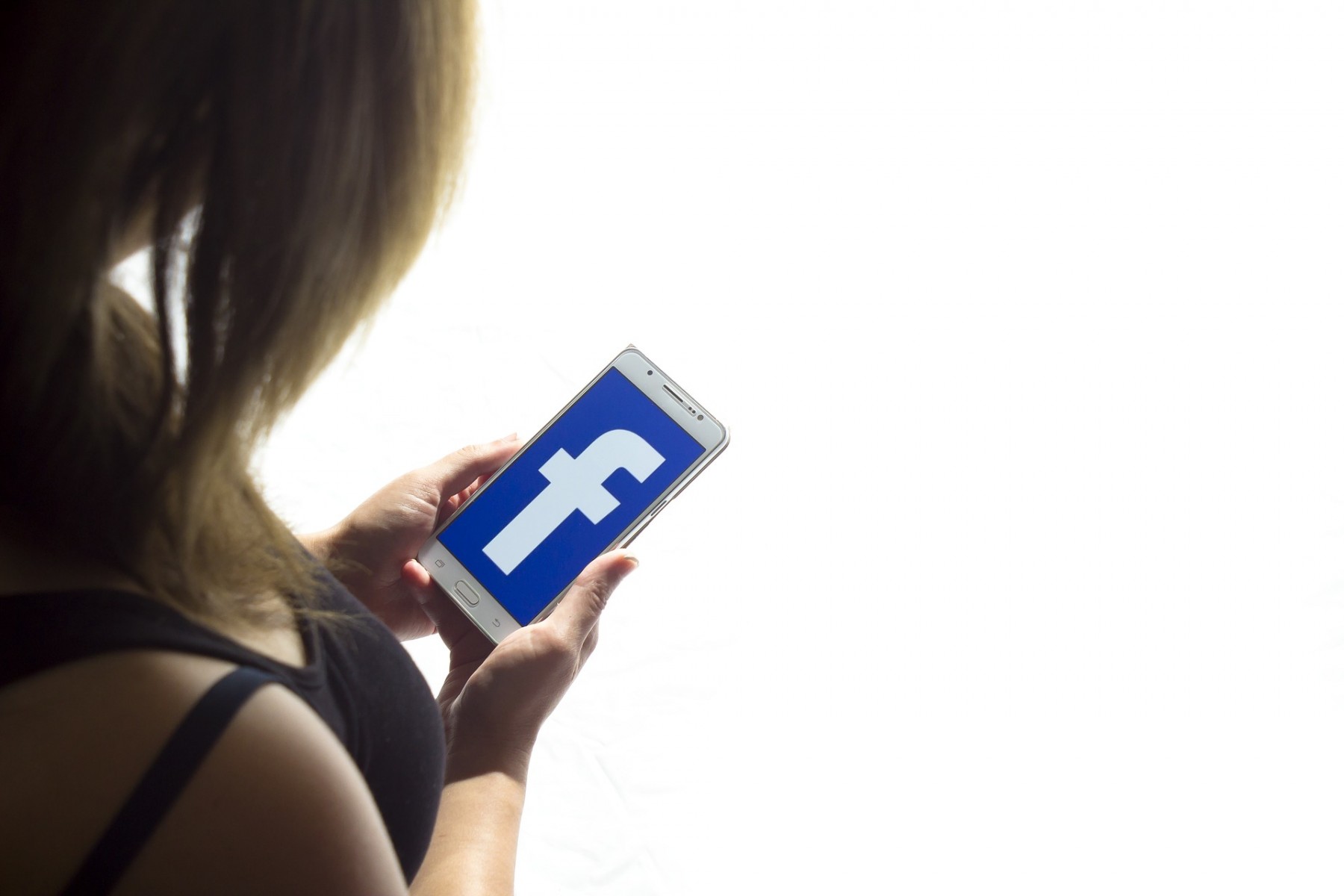 A person reads Facebook on a phone.