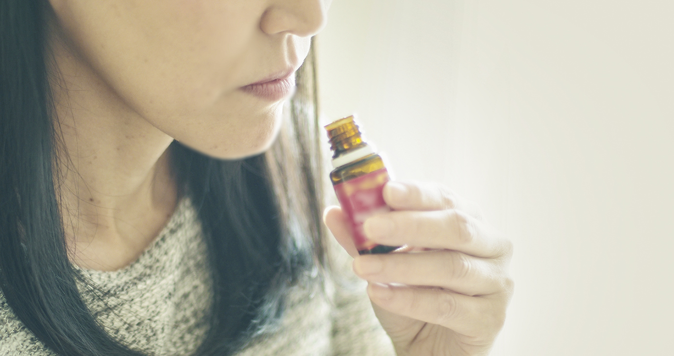 A woman smells an essential oil.