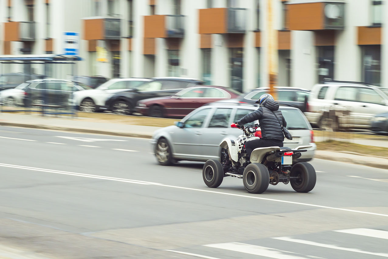 A man illegally rides an ATV on the street.