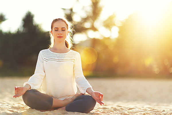 A woman meditates in the sun.