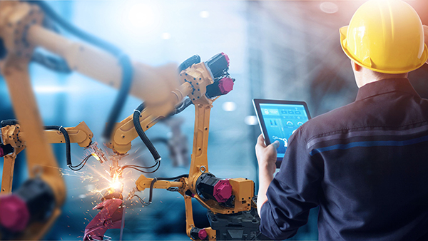 A person operates a robotic arm with a tablet.