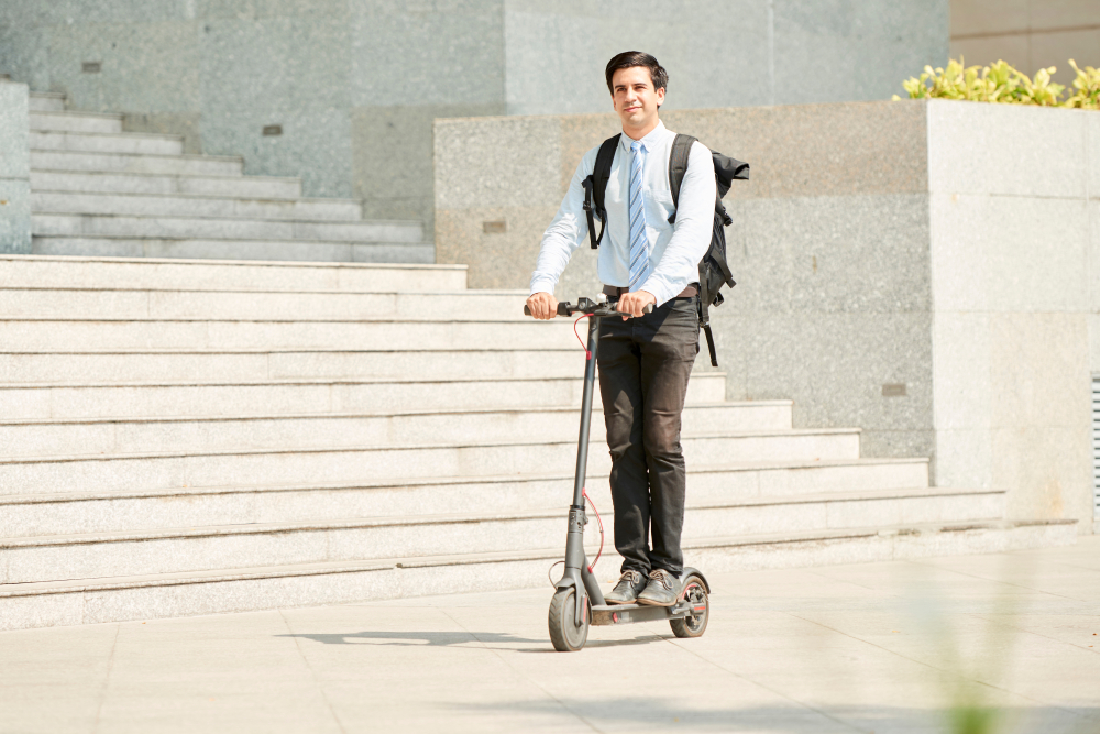 Man rides a motorized scooter without helmet.