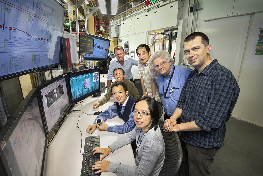 SBU team in front of countless computer monitors.