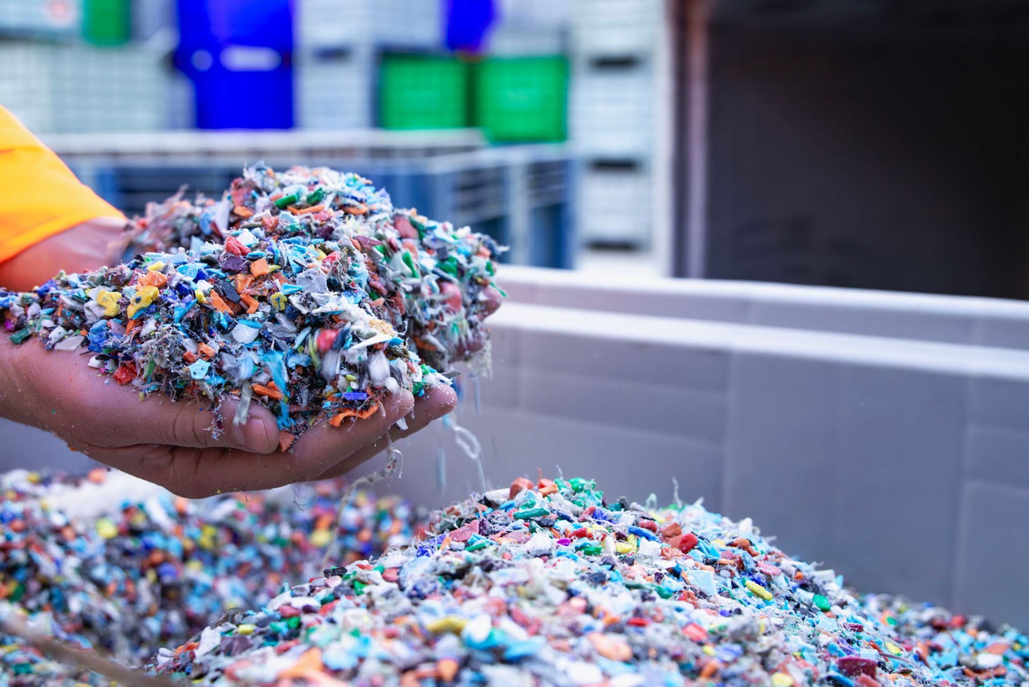 Hands cupping a small pile of shredded plastic waste