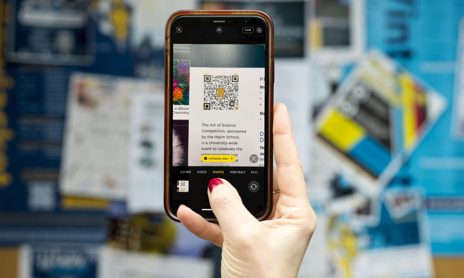 Person holding up a smartphone showing a QR code on the screen