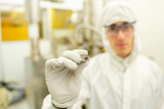 Scientists presents a tiny blue square device.