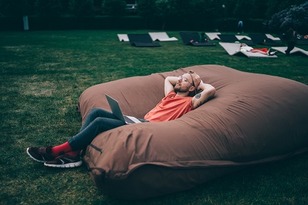 How You Feel About Social Interaction on Days With More Time Alone Depends on Why You Wanted to Be Alone, Study Finds; Person lounging on gigantic pillow in a field