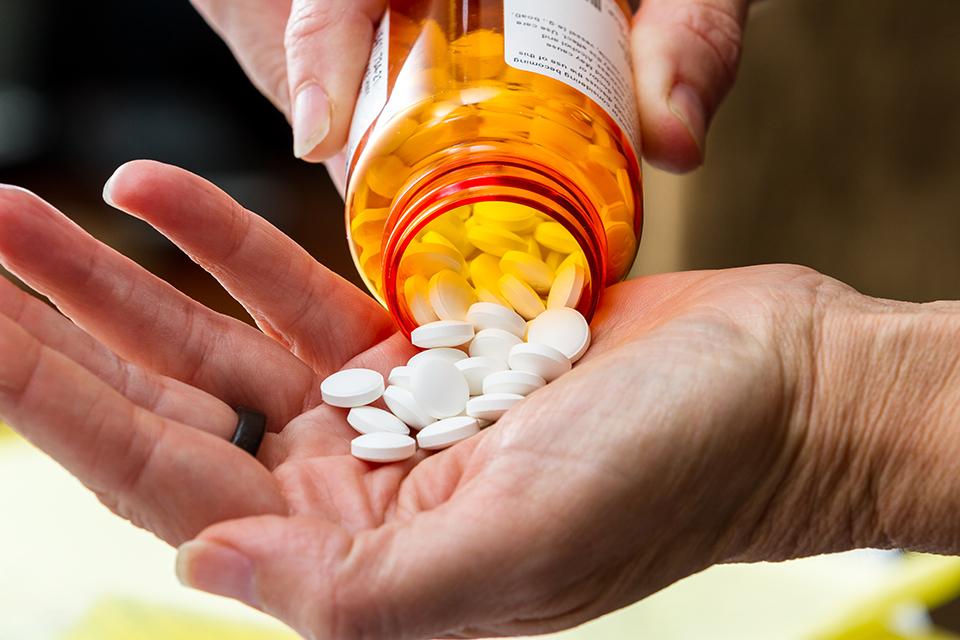 Pills being poured into a hand.