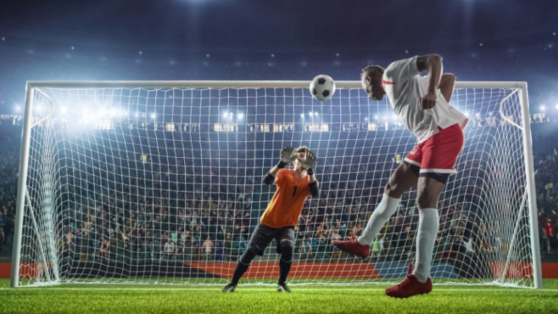 A soccer player headbutts a ball.