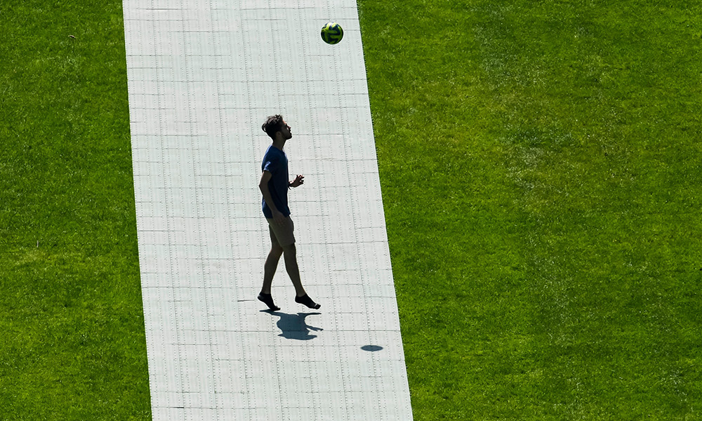 A young man plays soccer alone.