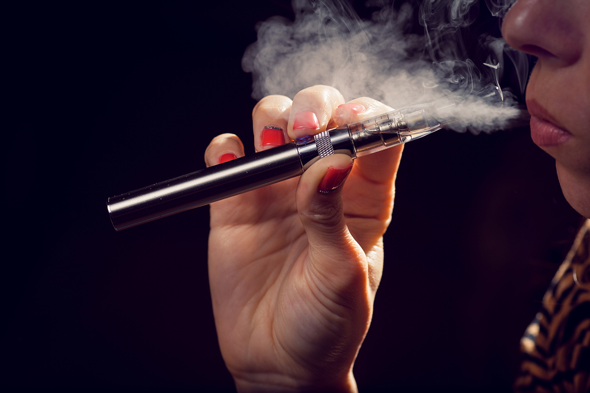 A woman smokes an e-cigarette