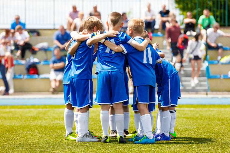 A youth soccer team huddles.