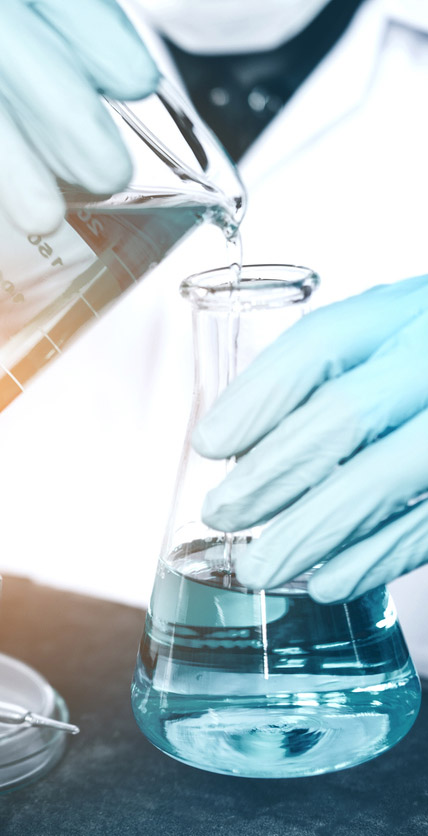 Lab technician pouring liquid into a beaker