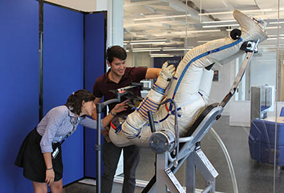 Recent graduate Diana Dayal and Carolina senior Bobby Hazel examine a mock head-down tilt test at the National Space Biomedical Research Institute.