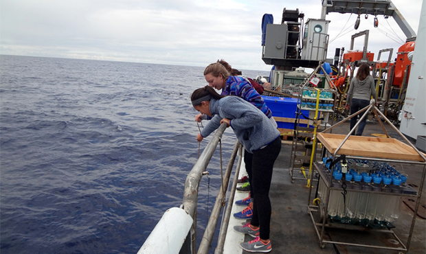 students looking over ships rail to the sea