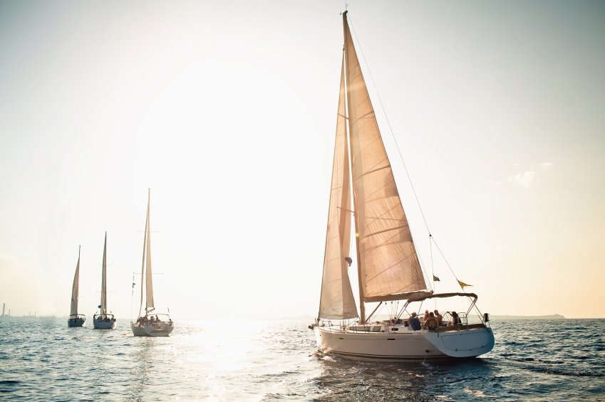 4 sailing boats in column on the water