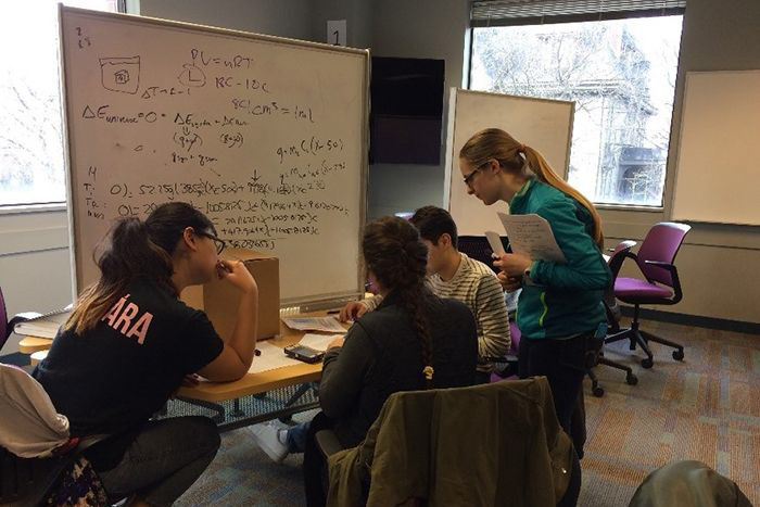 A graduate learning assistant works to help her peers in a classroom problem-solving session at Brown University.