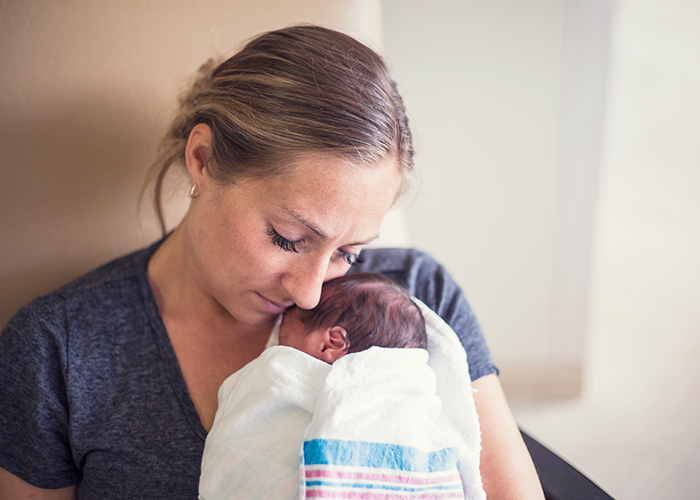 A Published Study Identifies a More Effective Way to Care for Opioid-Exposed Newborns; Stock image cradling a newborn child,