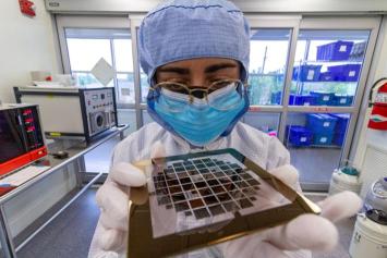An Ohio State University student holds a semiconductor at the university's Nanotech West Lab.