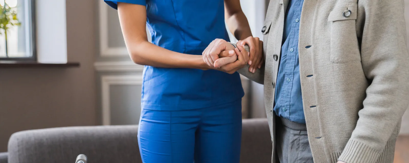 Nurse holding the hand of a man with Parkinson's disease