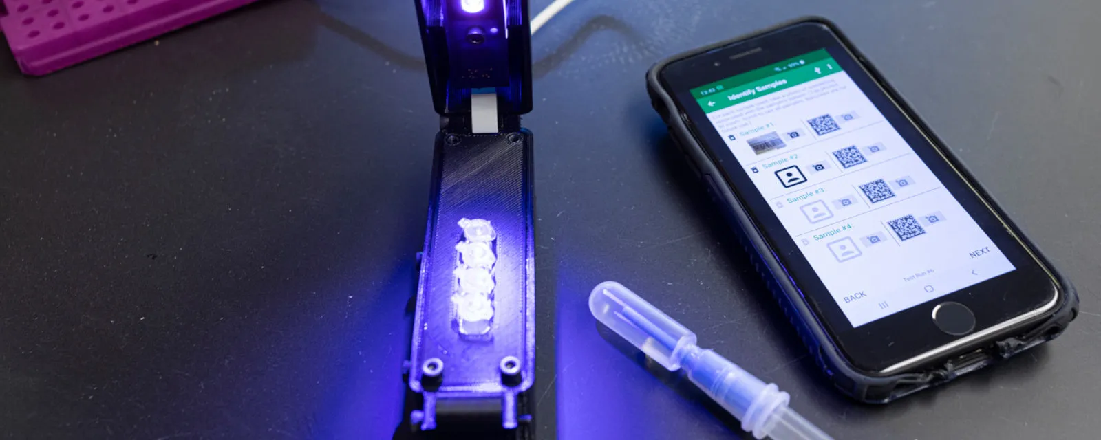 UV light next to cellphone showing test detecting COVID-19 virus genome