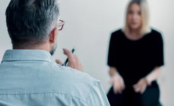 Image of counselor speaking with young woman.