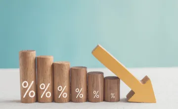 Wooden blocks with percentage symbols, each decreasing in size, accompanied by a downward pointing arrow. 