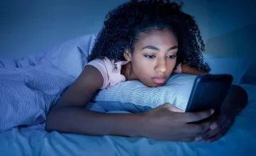 Teen Girls’ Texts Reveal Clues to Mental Health, Study Finds;  Teenage girl texting while laying on bed